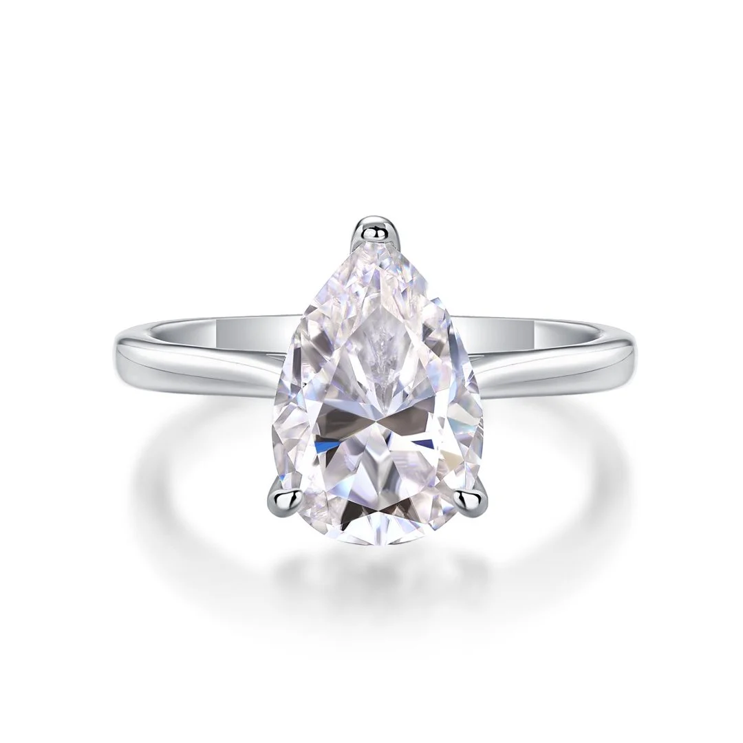 Pear solitaire ring on a smooth band on a white background